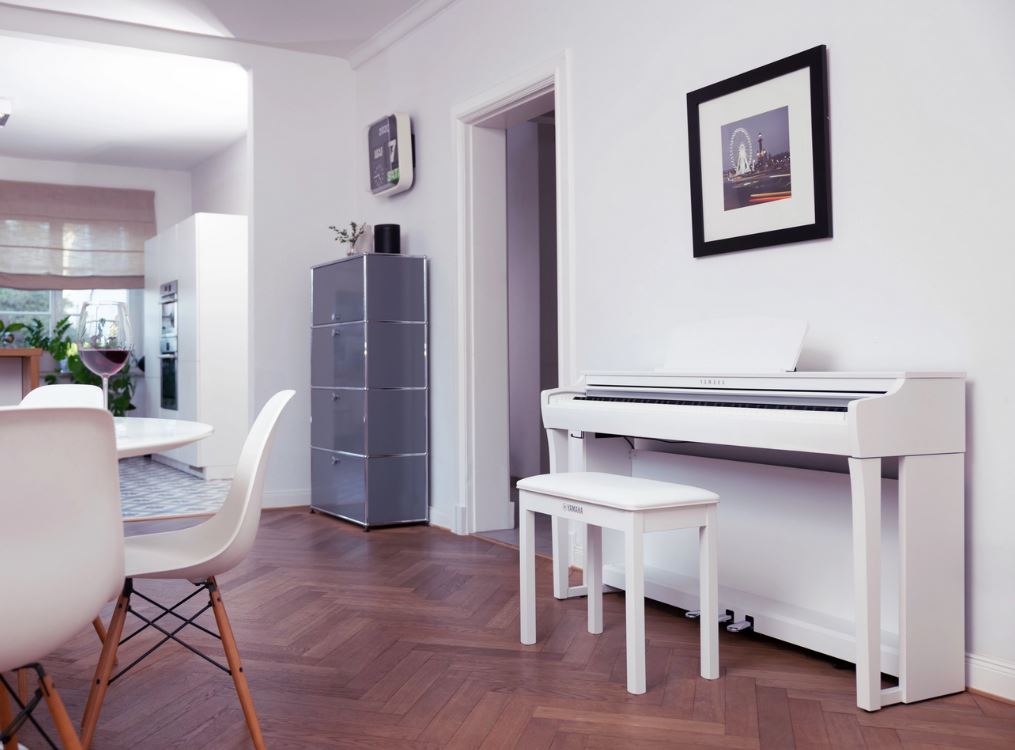 un piano blanc dans un salon prêt d'une table
