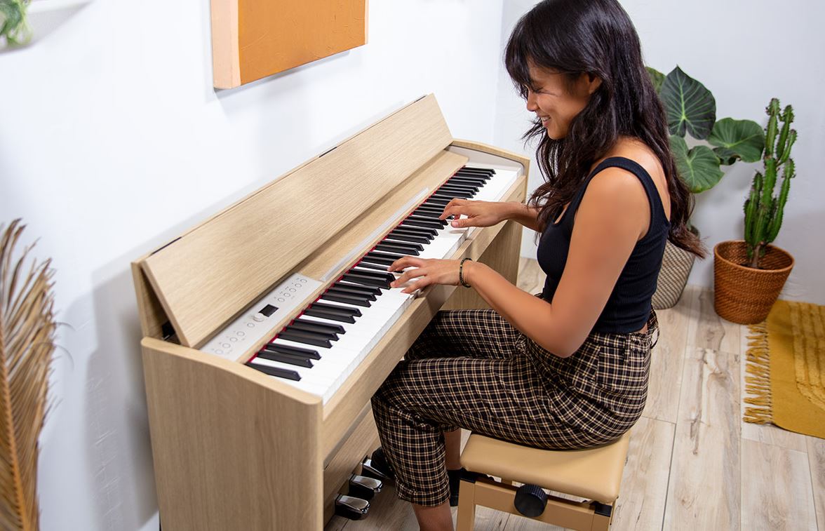 une femme joue du piano avec joie entourée de plantes