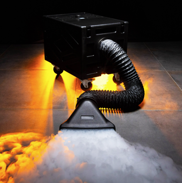 Tapis de brume dense et rasant sortant d'une machine à fumée lourde