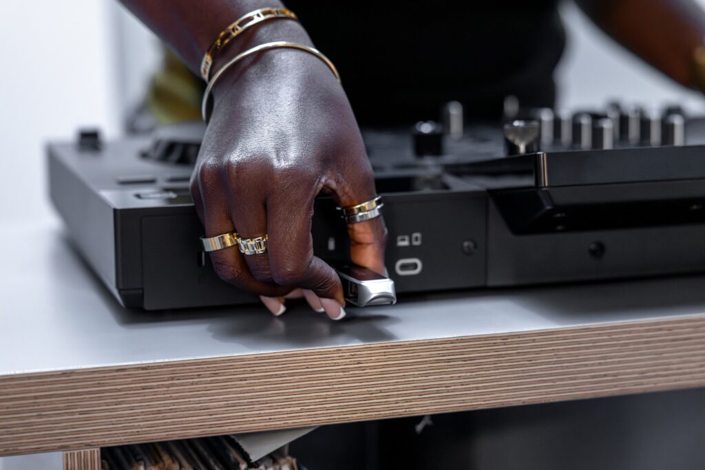 Main branchant une clé USB sur le contrôleur DJ AlphaTheta XDJ-AN pour charger une bibliothèque musicale depuis un support externe