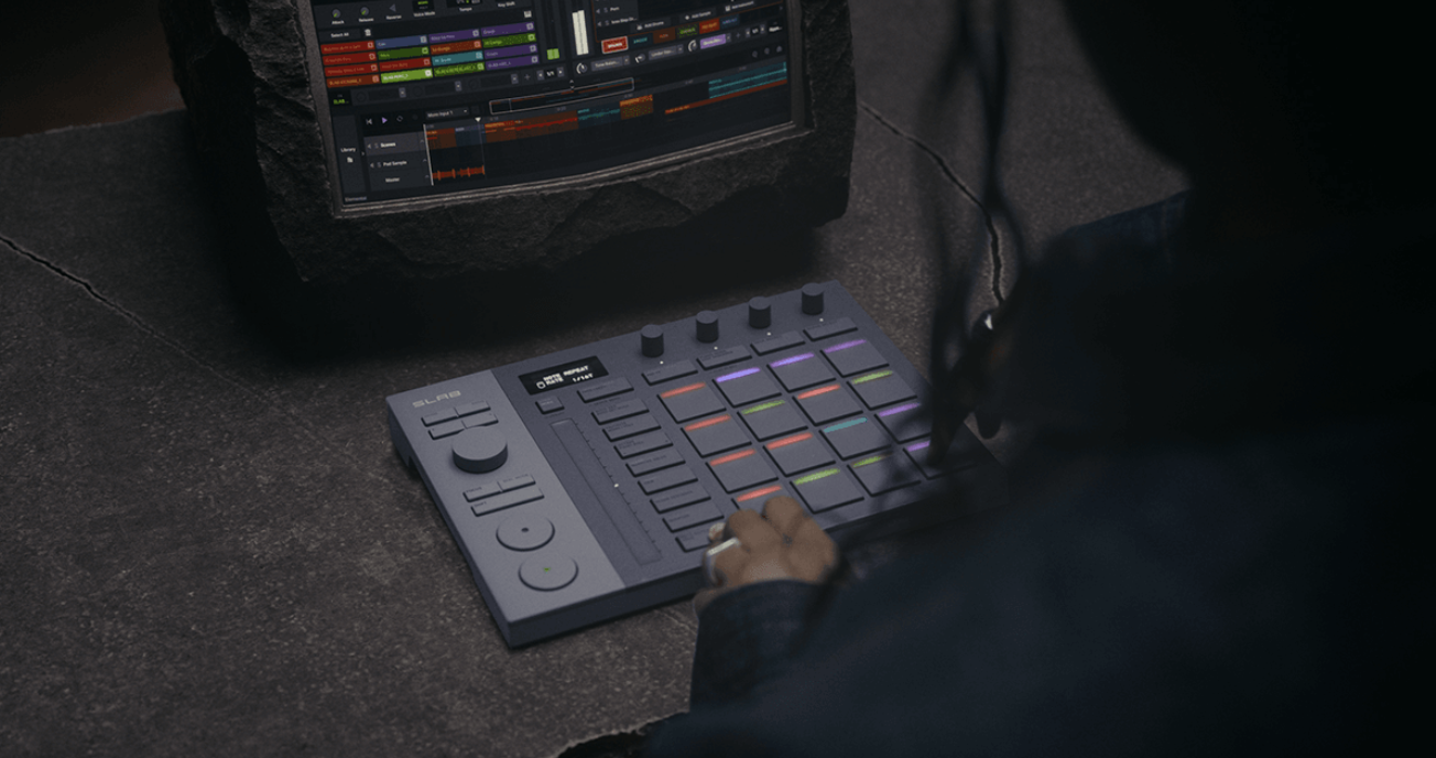 Producteur jouant sur les pads LED multicolores du contrôleur AlphaTheta SLAB connecté à un ordinateur portable affichant Serato Studio dans un environnement studio sombre