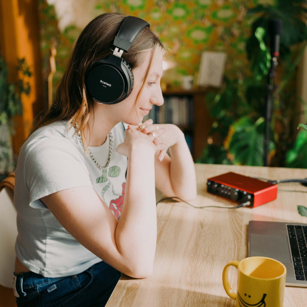 Interface audio Focusrite Scarlett rouge à deux entrées connectée à un ordinateur portable, utilisée avec un casque Scarlett SH-450 dans un home studio